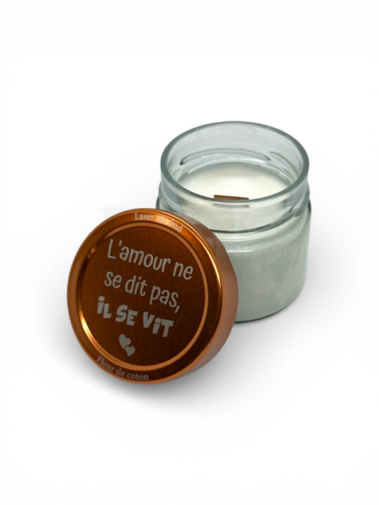 Bougie artisanale parfum au choix, ici Fleur de coton, pot en verre avec cire de tournesol et mèche en bois française, couvercle métallique cuivré gravé "L'amour ne se dit pas, il se vit" + petits cœurs gravés.